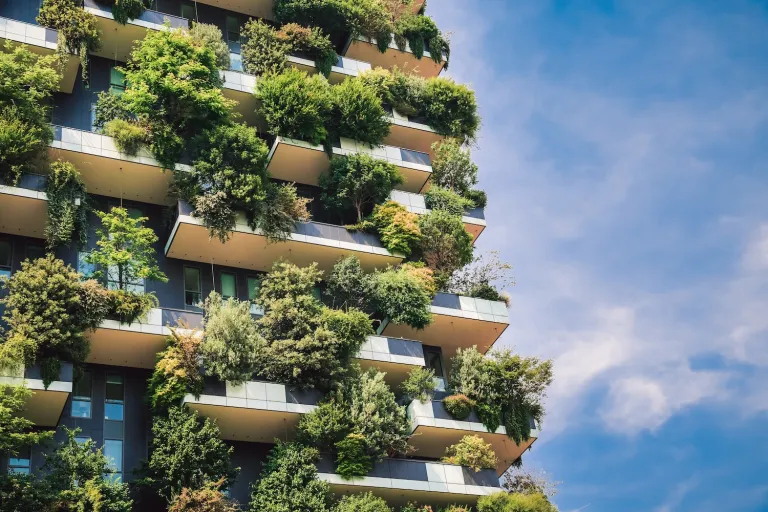 The side of a modern building featuring lots of plants